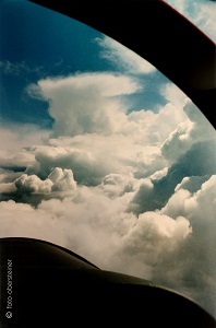 Foto von Wolken aufgenommen aus dem Cockpit eines Flugzeugs.